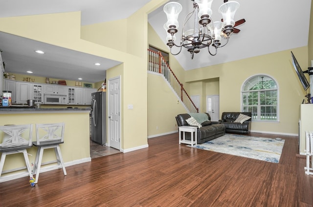 37323 Davey Jones Blvd, Greenbackville, VA 23356 - living room with a chandelier, high vaulted ceiling, dark wood-style flooring, stairway, and baseboards