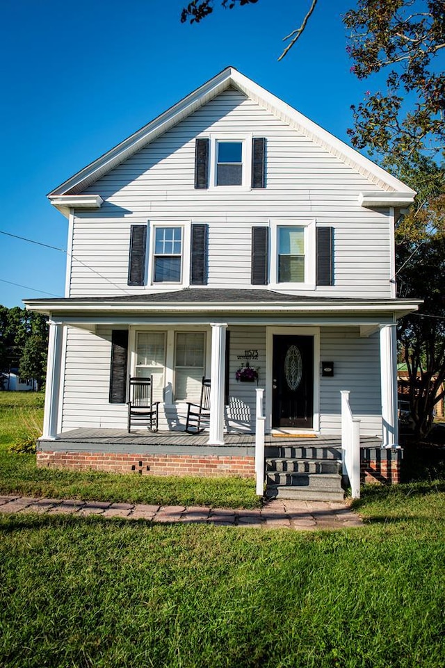 view of front of home with a porch and a front yard