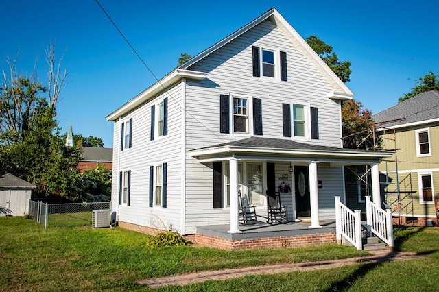 view of front of house with cooling unit, covered porch, a front yard, and fence