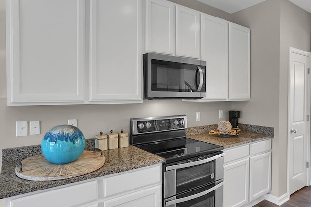 kitchen featuring white cabinets, dark stone counters, and appliances with stainless steel finishes