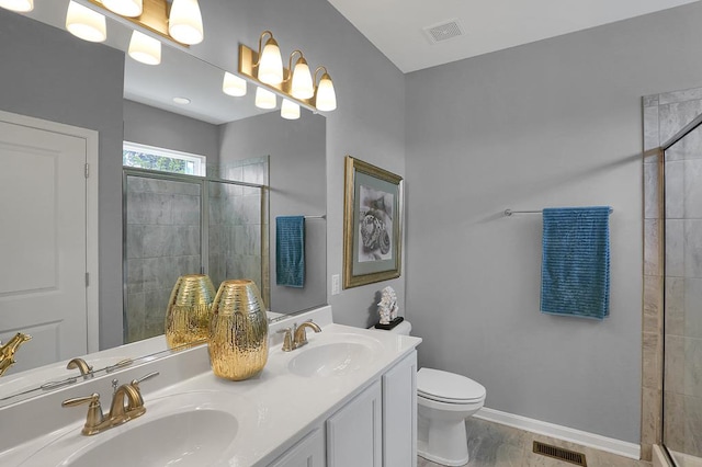 bathroom with a tile shower, vanity, and toilet