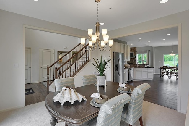 carpeted dining room with a notable chandelier and sink