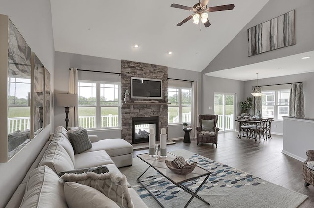 living room featuring a fireplace, wood-type flooring, high vaulted ceiling, and plenty of natural light