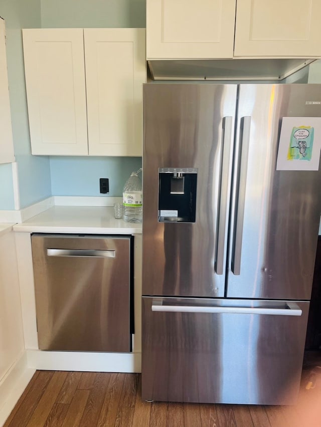 kitchen featuring stainless steel appliances, wood finished floors, white cabinets, and light countertops