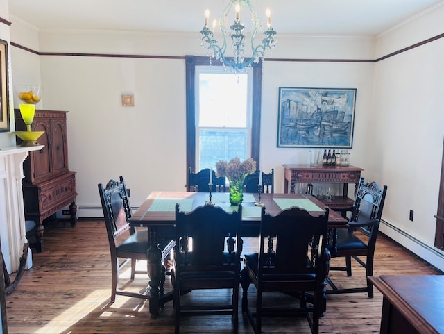 dining area featuring a chandelier, ornamental molding, a baseboard heating unit, and wood finished floors