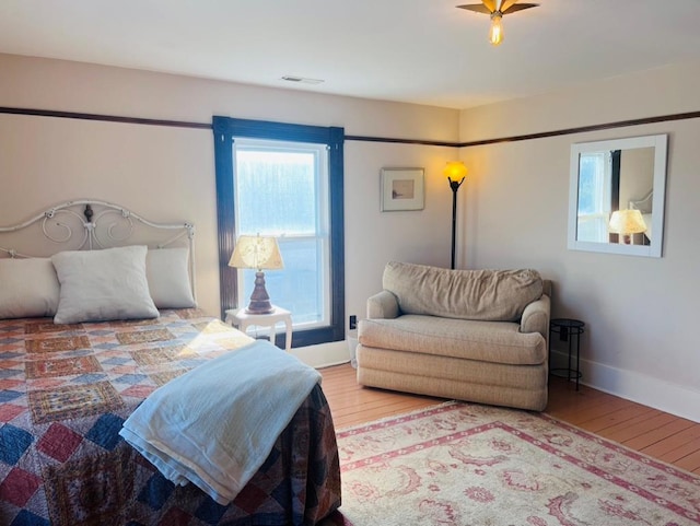 bedroom with visible vents, baseboards, and hardwood / wood-style floors