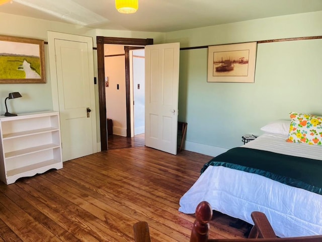 bedroom with wood finished floors and baseboards