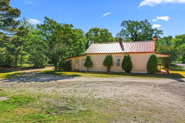 9333 Red Bank Rd, Nassawadox, VA 23413 - view of home's exterior featuring a chimney, metal roof, and a lawn