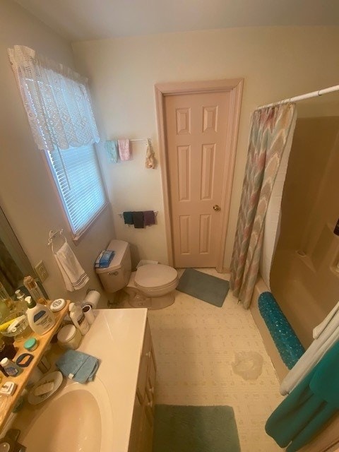 bathroom with curtained shower, vanity, and toilet