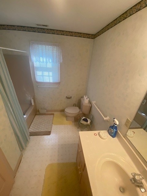 full bathroom featuring toilet, sink, and bathing tub / shower combination