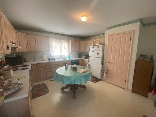 kitchen featuring light brown cabinets and black appliances