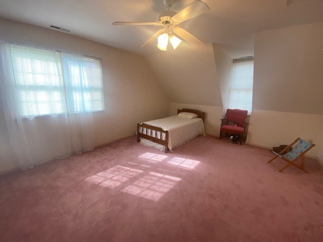 unfurnished bedroom featuring carpet flooring, ceiling fan, and lofted ceiling