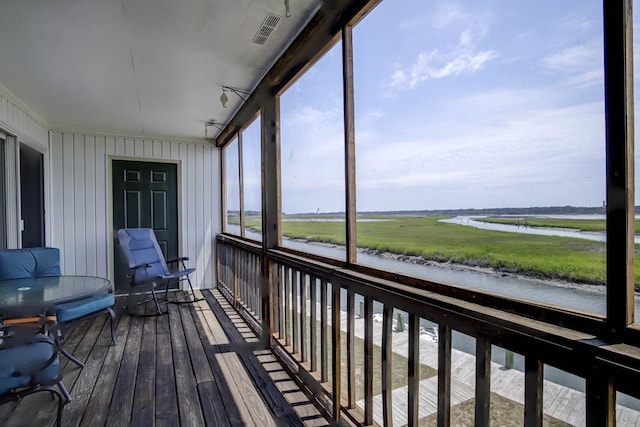 unfurnished sunroom featuring a water view