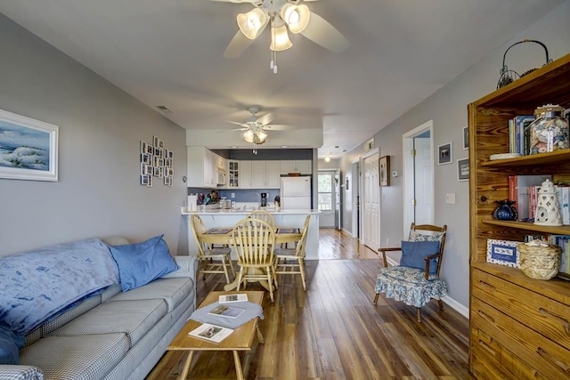 living room featuring dark wood-type flooring and ceiling fan