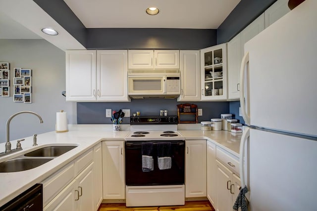 kitchen with sink, white appliances, and white cabinets