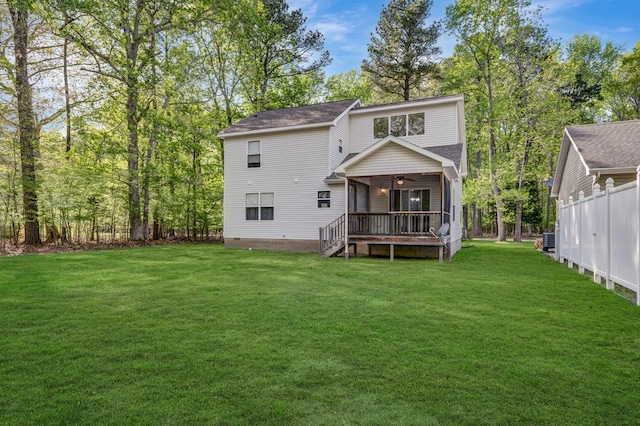 rear view of property with a lawn, crawl space, ceiling fan, and fence