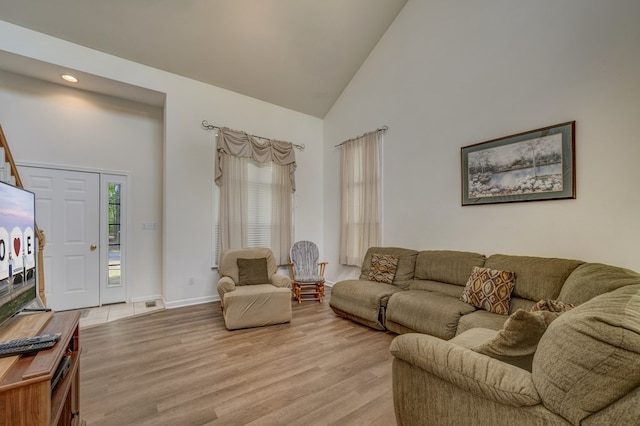 living area with high vaulted ceiling, baseboards, recessed lighting, and light wood-style flooring
