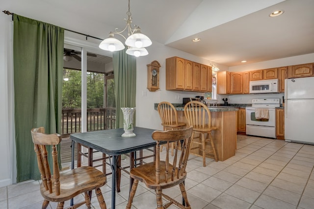 kitchen featuring dark countertops, light tile patterned floors, ceiling fan with notable chandelier, a peninsula, and white appliances