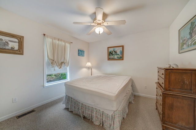 bedroom featuring baseboards, visible vents, light carpet, and ceiling fan