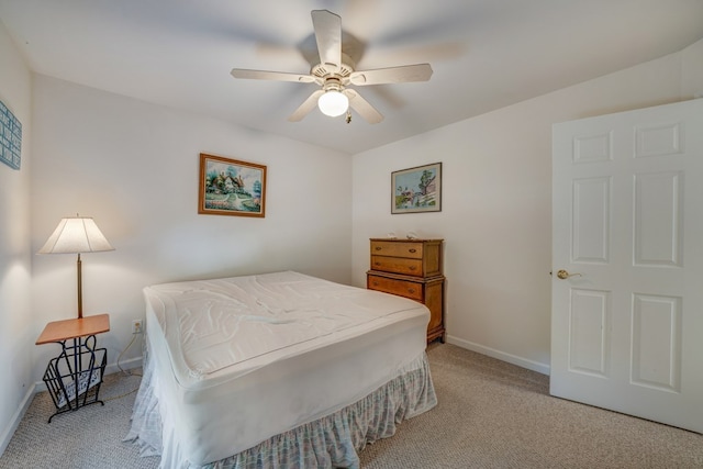 bedroom featuring light colored carpet, baseboards, and ceiling fan