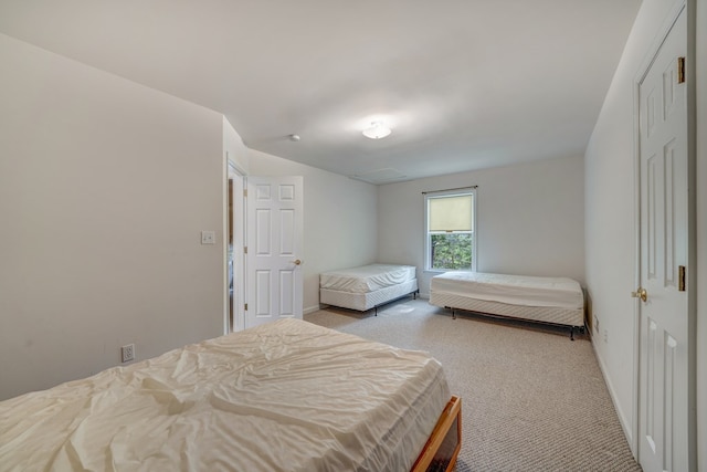 bedroom with baseboards and light carpet