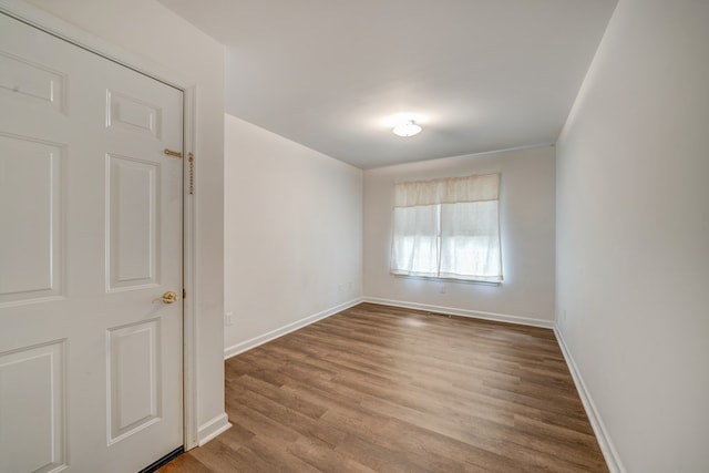 empty room featuring baseboards and wood finished floors