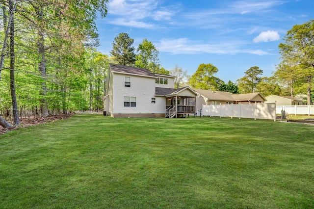 back of property featuring a yard, crawl space, fence, and stairs