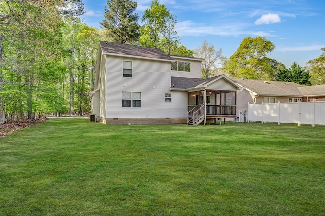rear view of house with a lawn, crawl space, and fence