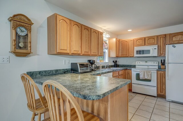 kitchen with a peninsula, a toaster, white appliances, a kitchen breakfast bar, and light tile patterned floors