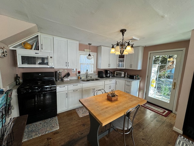 kitchen with an inviting chandelier, white cabinets, black gas stove, sink, and hanging light fixtures