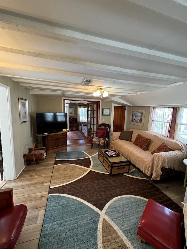 living room featuring beamed ceiling and wood-type flooring