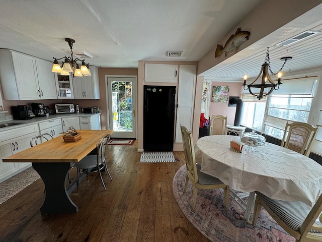 dining room with a chandelier, dark hardwood / wood-style floors, and sink