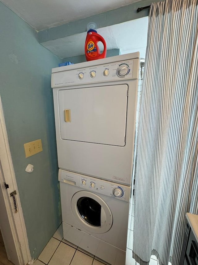 laundry room featuring light tile patterned flooring and stacked washer and dryer