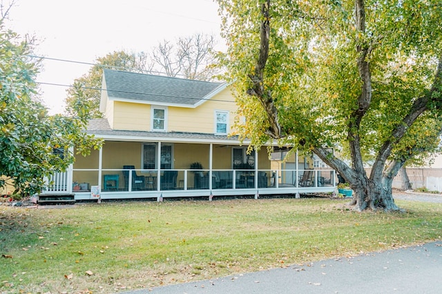 view of front of house featuring a sunroom and a front yard