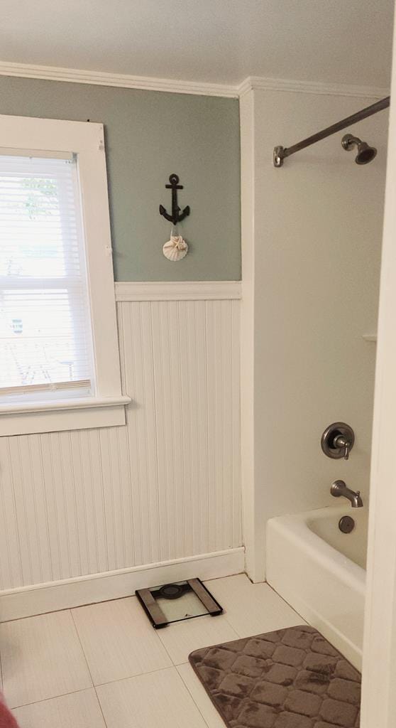 bathroom with tile patterned flooring, washtub / shower combination, and ornamental molding