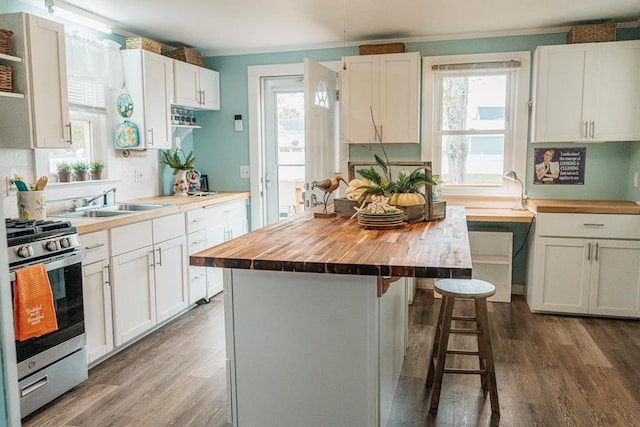 kitchen with white cabinets, butcher block countertops, and stainless steel range with gas stovetop