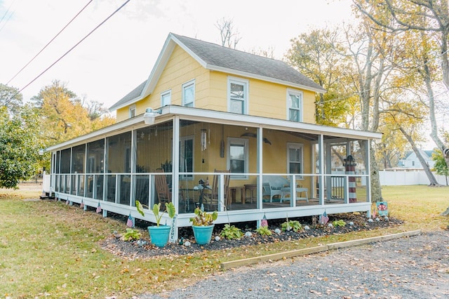 view of home's exterior with a lawn and a sunroom