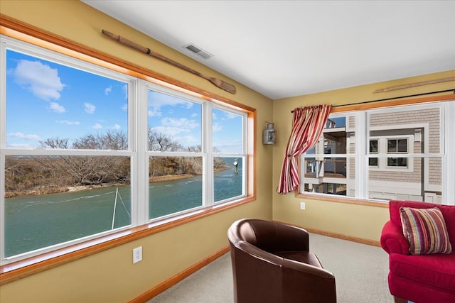 living area with carpet, visible vents, and baseboards