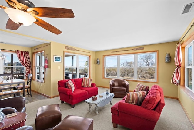 living area featuring carpet flooring, a healthy amount of sunlight, visible vents, and baseboards