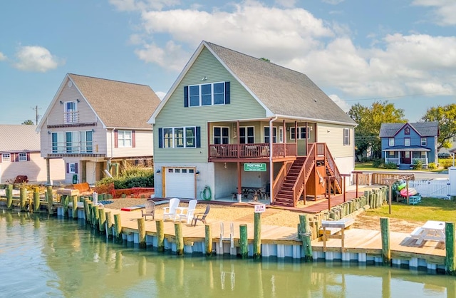 back of property featuring a garage, a patio, fence, stairway, and a deck with water view