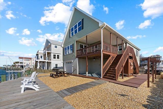 rear view of property featuring stairway, a garage, a residential view, and a wooden deck