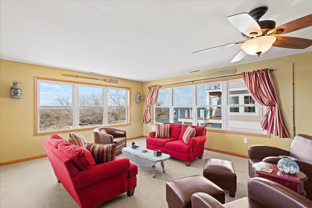 carpeted living room with ceiling fan and baseboards