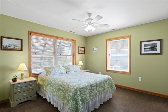 bedroom featuring visible vents, a ceiling fan, baseboards, and dark colored carpet