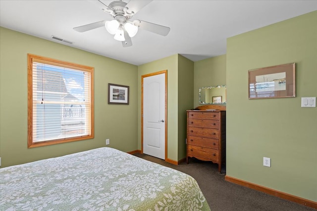 bedroom featuring visible vents, a ceiling fan, baseboards, and dark colored carpet