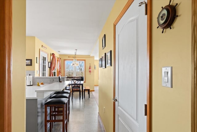 interior space with pendant lighting, a peninsula, a breakfast bar area, and light countertops