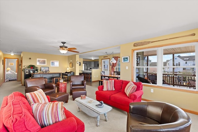 living room featuring baseboards, carpet floors, and ceiling fan