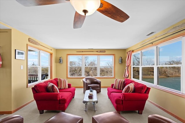 living area featuring carpet flooring, plenty of natural light, visible vents, and baseboards