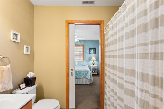 ensuite bathroom featuring visible vents, toilet, ensuite bathroom, a shower with shower curtain, and vanity