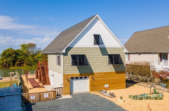 view of front of property with stairway, an attached garage, gravel driveway, and fence