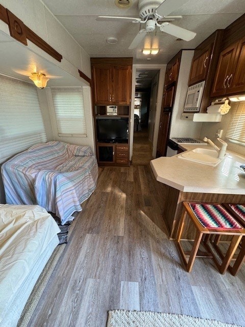 bedroom featuring ceiling fan, dark hardwood / wood-style flooring, and sink